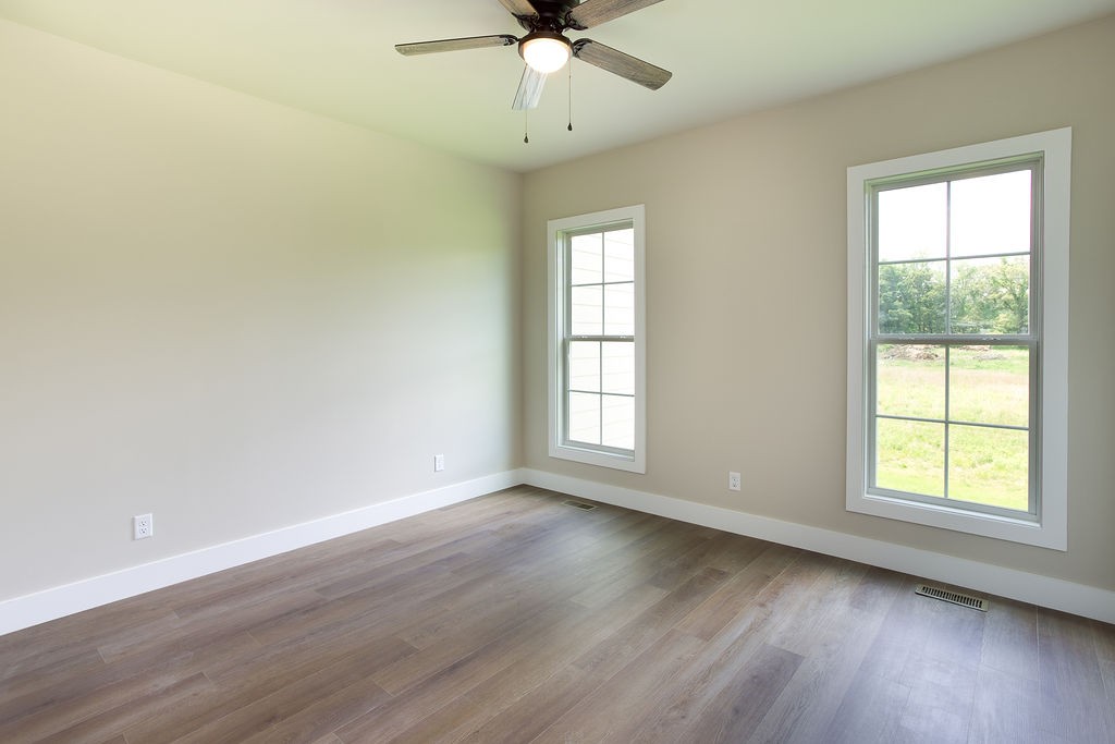 807 Oconner Smithville, TN 37166 - Photo 23 of 33 an empty room with wooden floor chandelier fan and windows