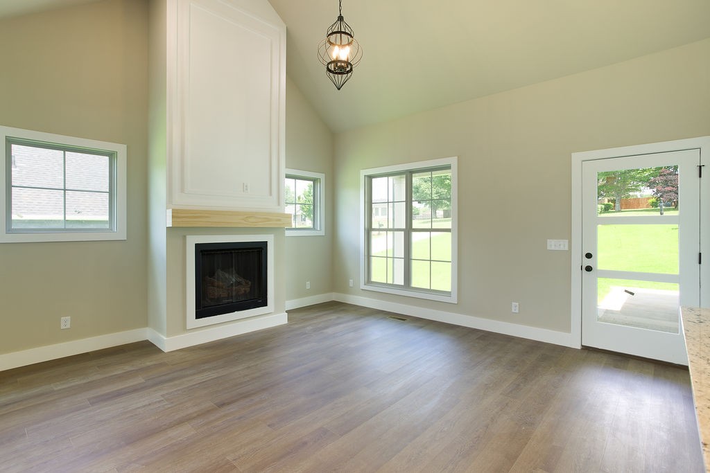 807 Oconner Smithville, TN 37166 - Photo 4 of 33 an empty room with wooden floor a fireplace and windows