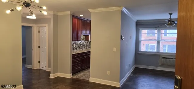 a view of hallway with chandelier and wooden floor