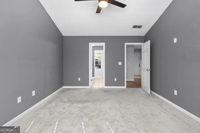 a view of an empty room with a ceiling fan