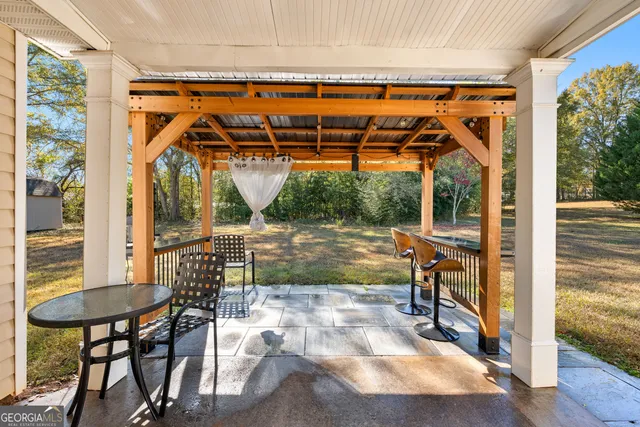 a view of porch with a table and chairs