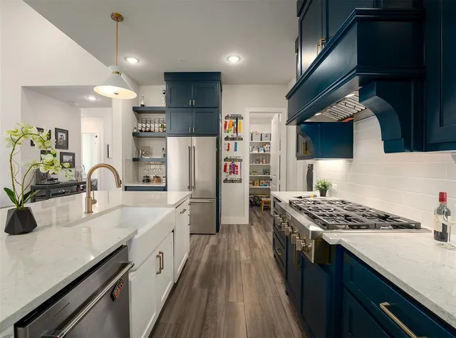 a kitchen with stainless steel appliances granite countertop a sink stove and refrigerator