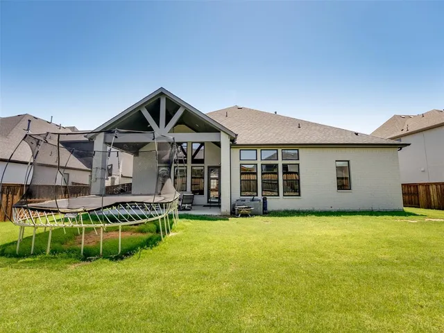 a view of a house with a big yard and large trees