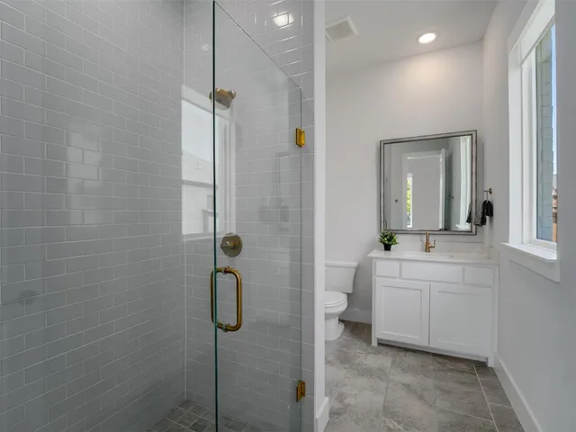 a bathroom with a sink a toilet and shower