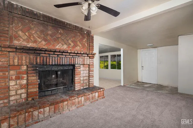 a view of empty room with fireplace and fan