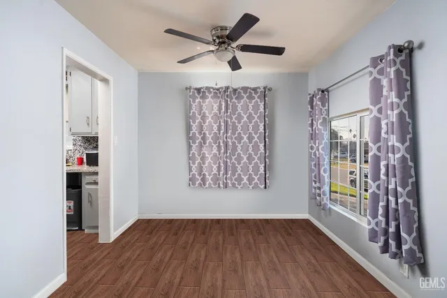 a view of an empty room with window and wooden floor