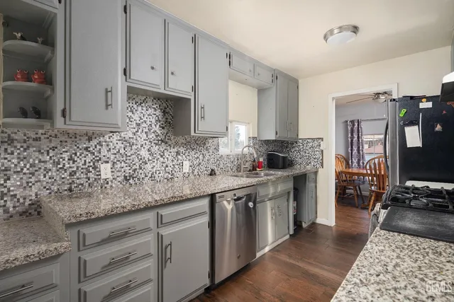 a kitchen with stainless steel appliances granite countertop a sink stove and cabinets