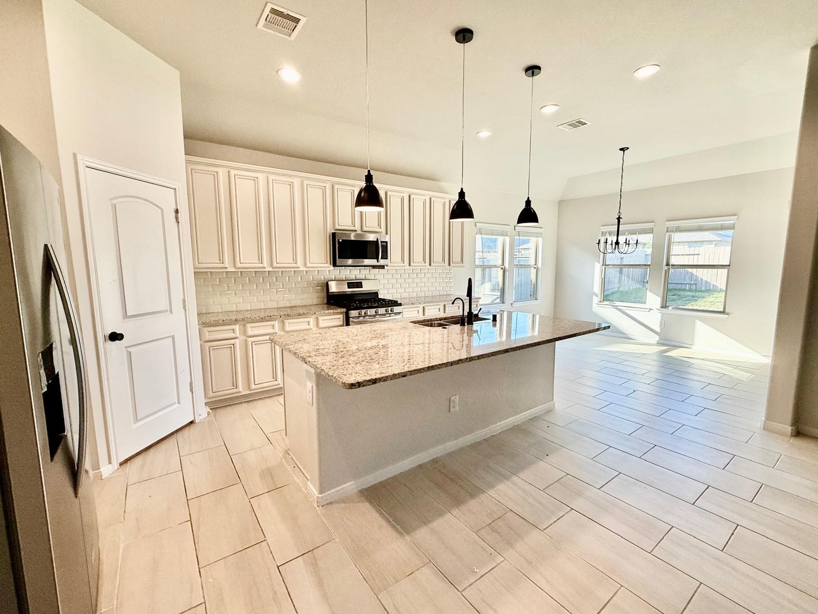 14208 Wallowa Ridge Lane Conroe, TX 77384 - Photo 35 of 48 a kitchen with stainless steel appliances a refrigerator sink and microwave