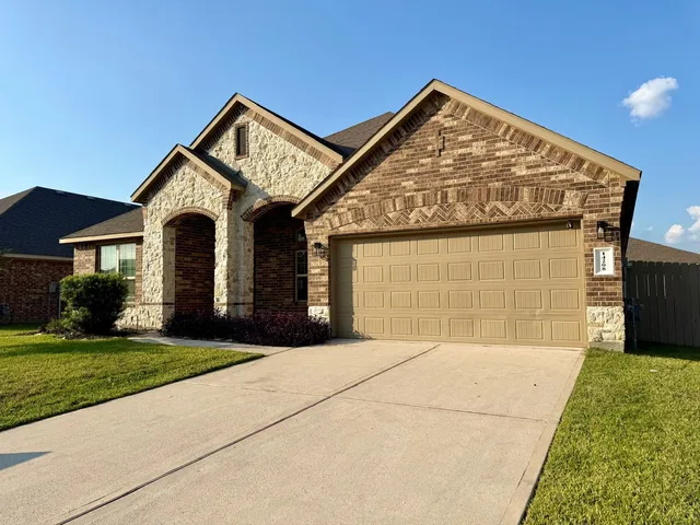 a front view of a house with a garden and garage