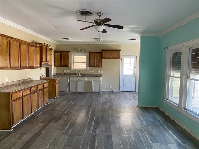 a large kitchen with cabinets wooden floor and stainless steel appliances