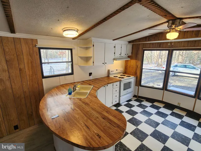 a kitchen with stainless steel appliances granite countertop a stove a sink and a window