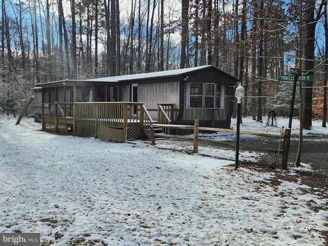 a view of wooden house with a large window and wooden fence