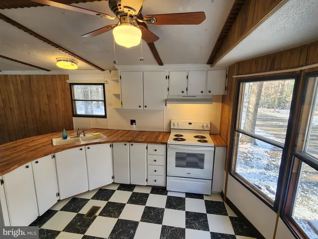 a kitchen with a refrigerator a sink and a mirror