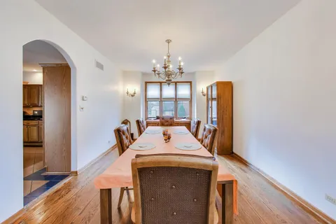 a view of a dining room with furniture wooden floor and chandelier