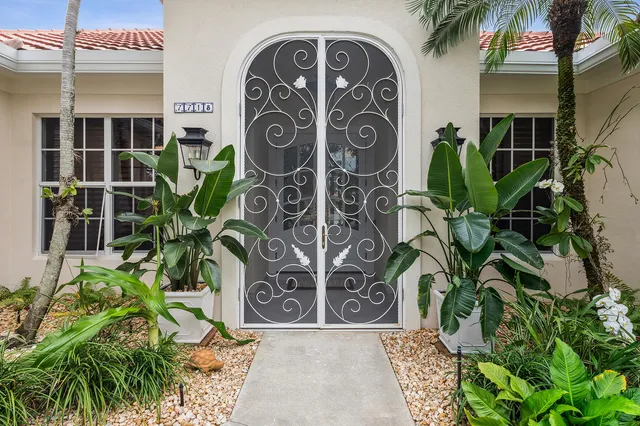 a view of front door with potted plants