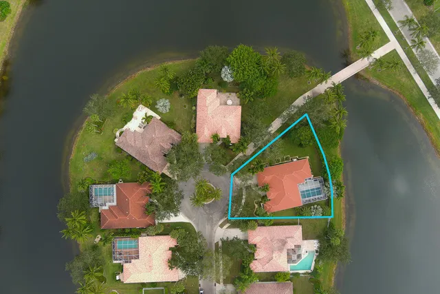 an aerial view of residential houses with outdoor space and lake view