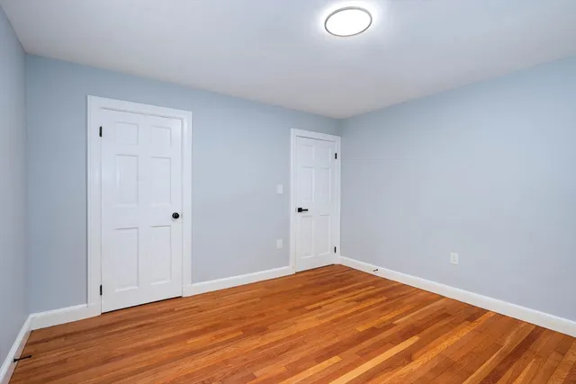 a view of a hallway with wooden floor and closet area