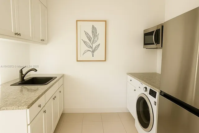 a utility room with sink dryer and washer