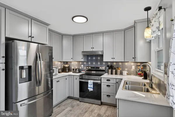 a kitchen with cabinets appliances a sink and a counter top