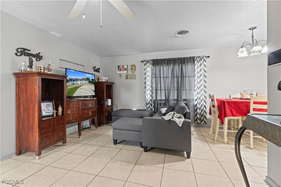 117 Texas Road Lehigh Acres, FL 33936 - Photo 11 of 19 a living room with furniture and a flat screen tv