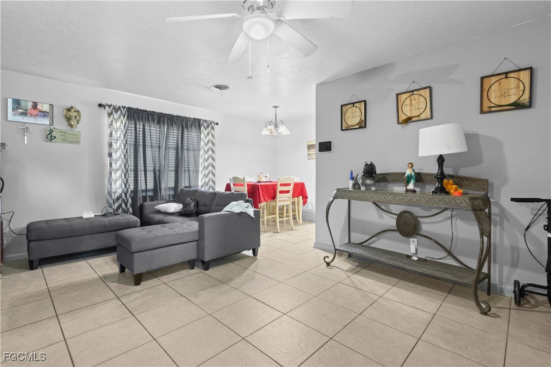 117 Texas Road Lehigh Acres, FL 33936 - Photo 3 of 19 a living room with furniture and a chandelier