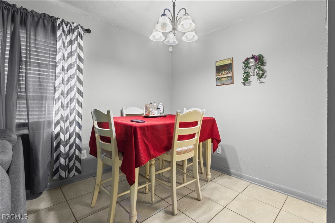 117 Texas Road Lehigh Acres, FL 33936 - Photo 6 of 19 a view of a dining room with furniture and chandelier