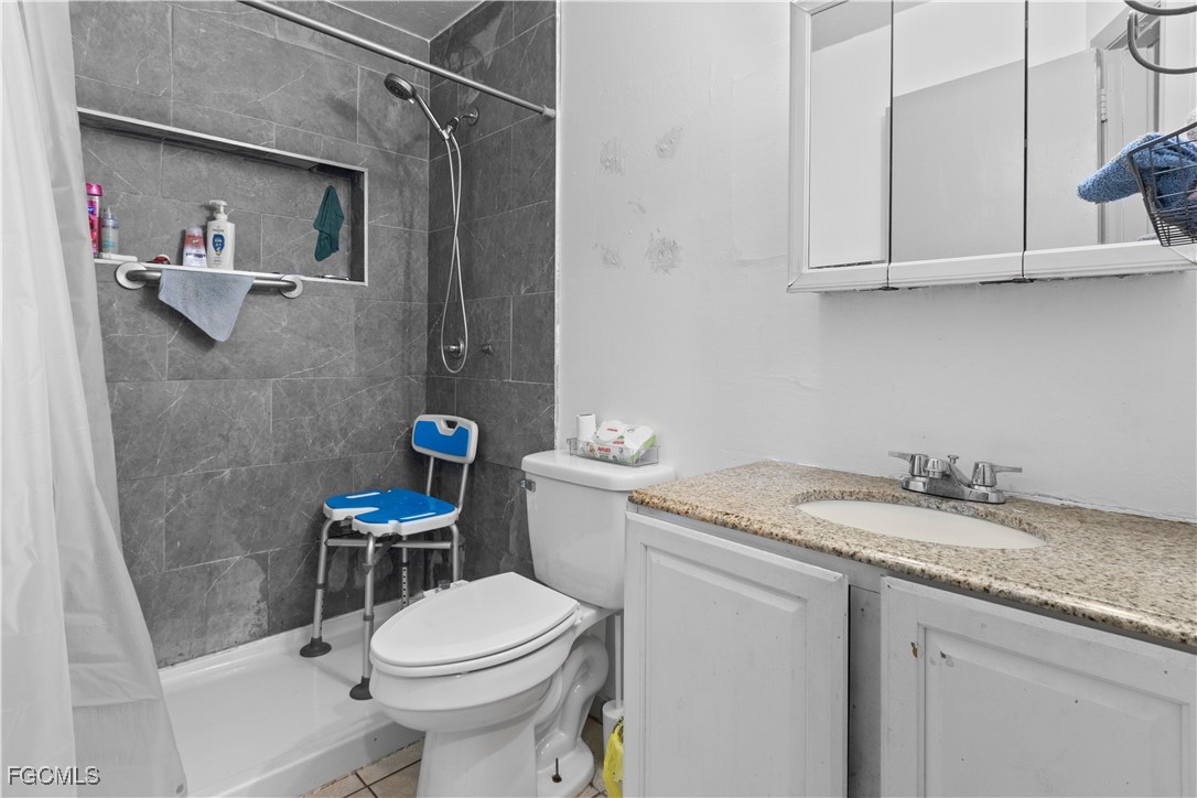 117 Texas Road Lehigh Acres, FL 33936 - Photo 9 of 19 a bathroom with a granite countertop toilet sink and mirror