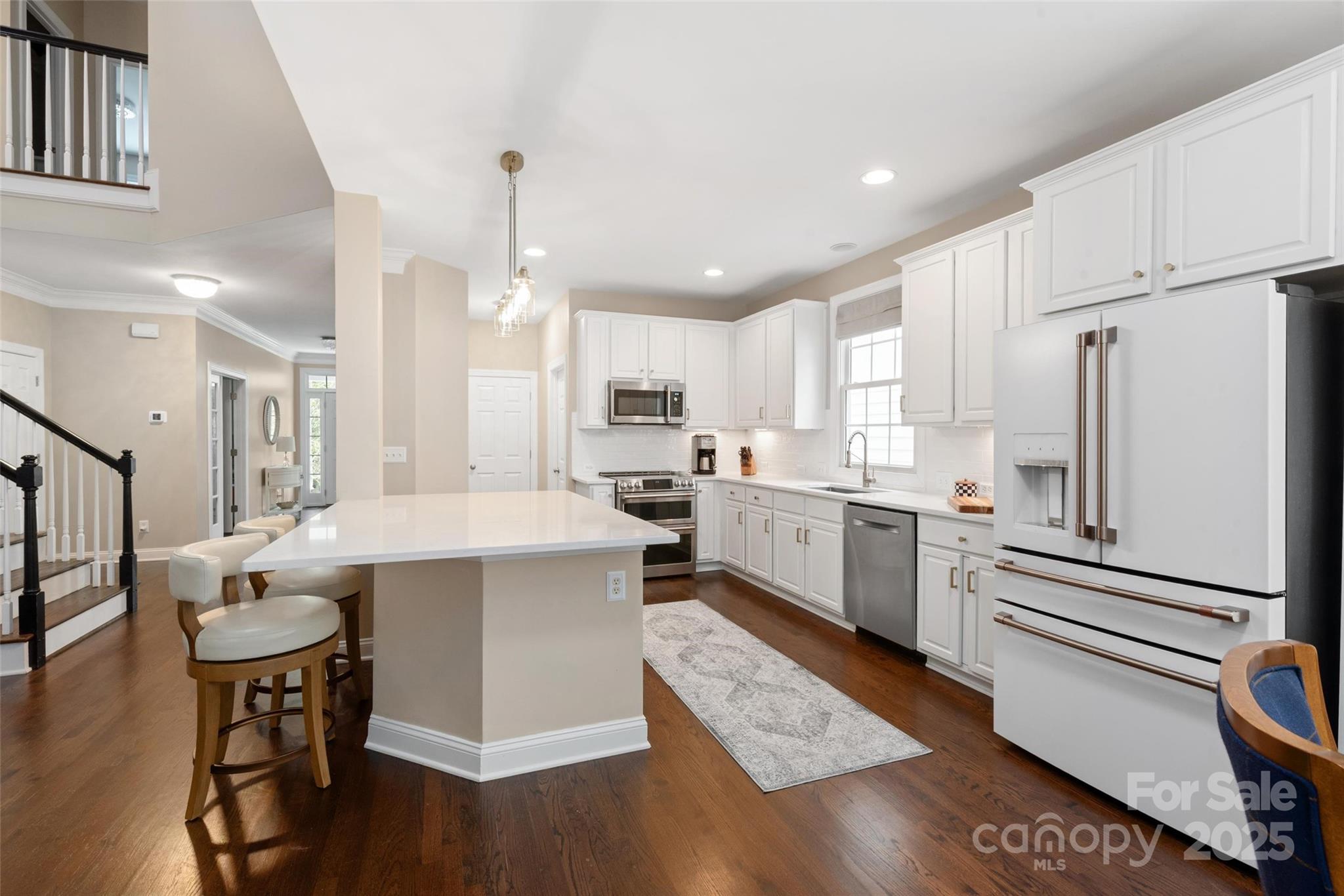 875 Stratford Run Drive Fort Mill, SC 29708 - Photo 6 of 37 a kitchen with a refrigerator a stove top oven a sink dishwasher and white cabinets with wooden floor