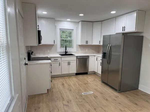 a kitchen with wooden cabinets and white stainless steel appliances