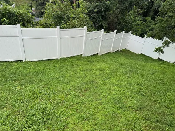 a view of a backyard with white fence
