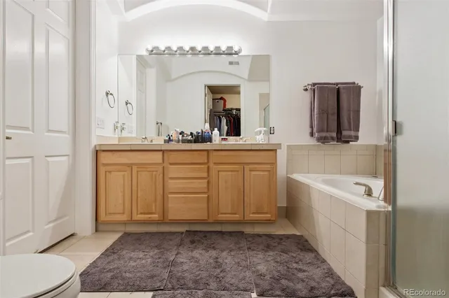 a spacious bathroom with a sink a mirror a vanity and bathtub