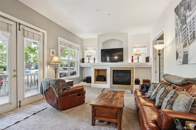 a living room with furniture a flat screen tv and a fireplace