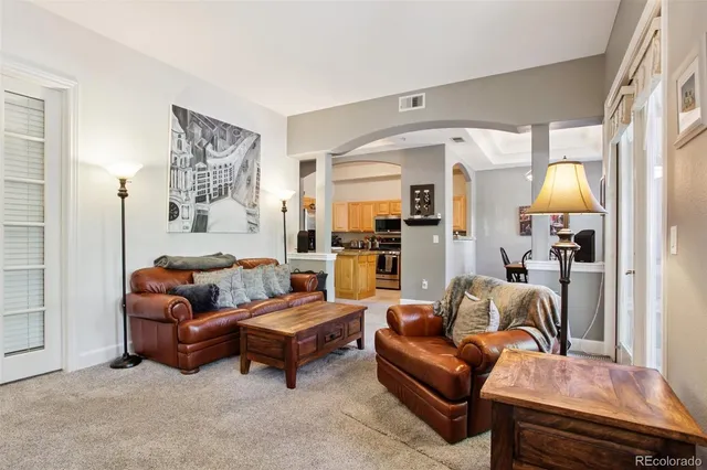 a living room with furniture a lamp and a large window