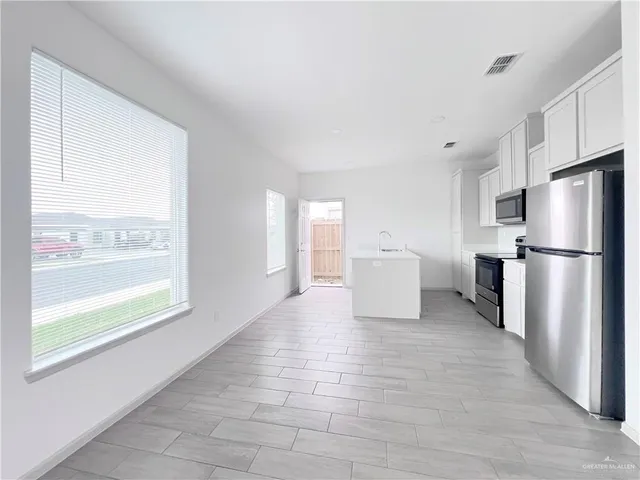 an empty room with windows and fan