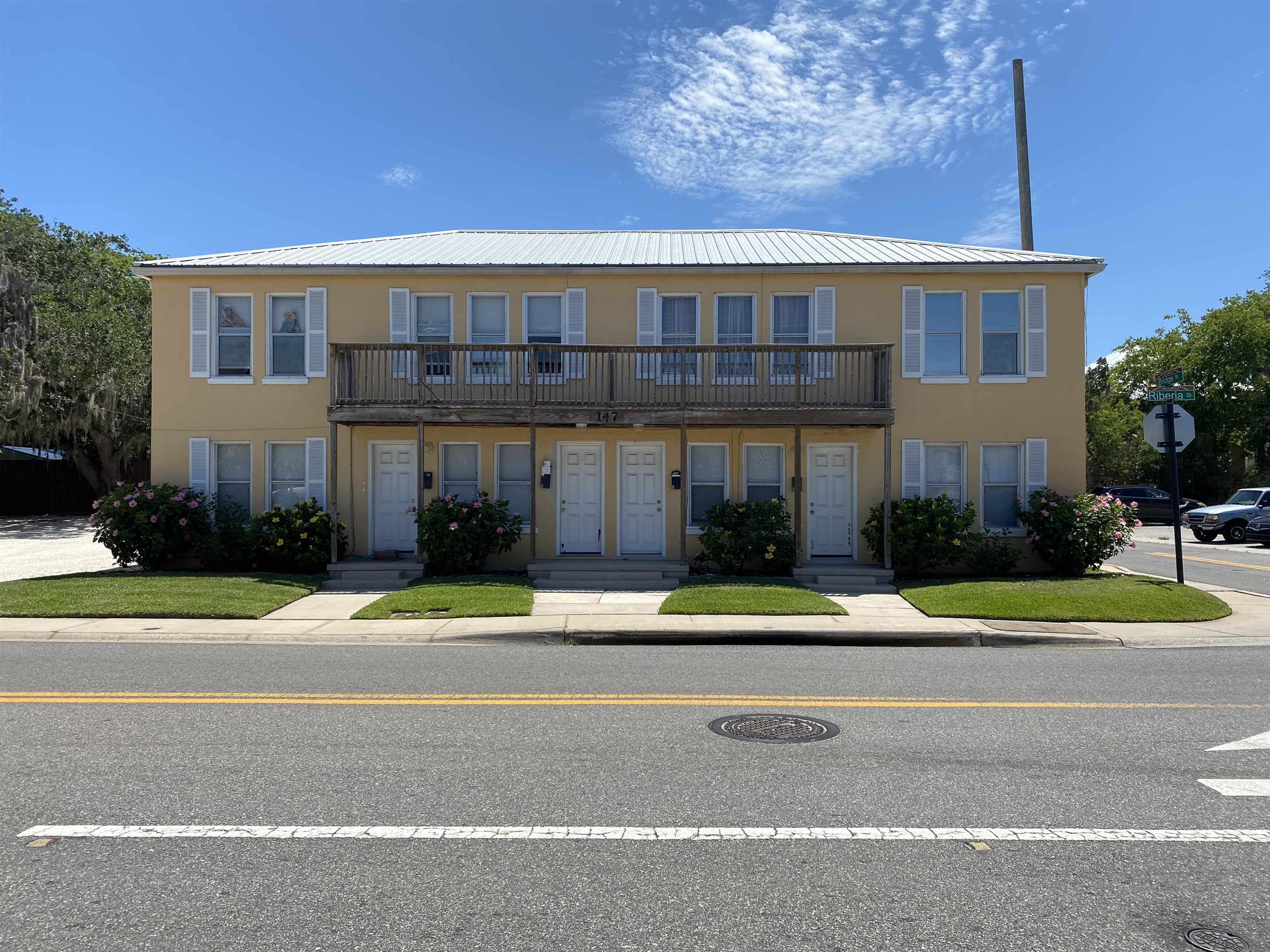 a front view of a house with a yard and trees