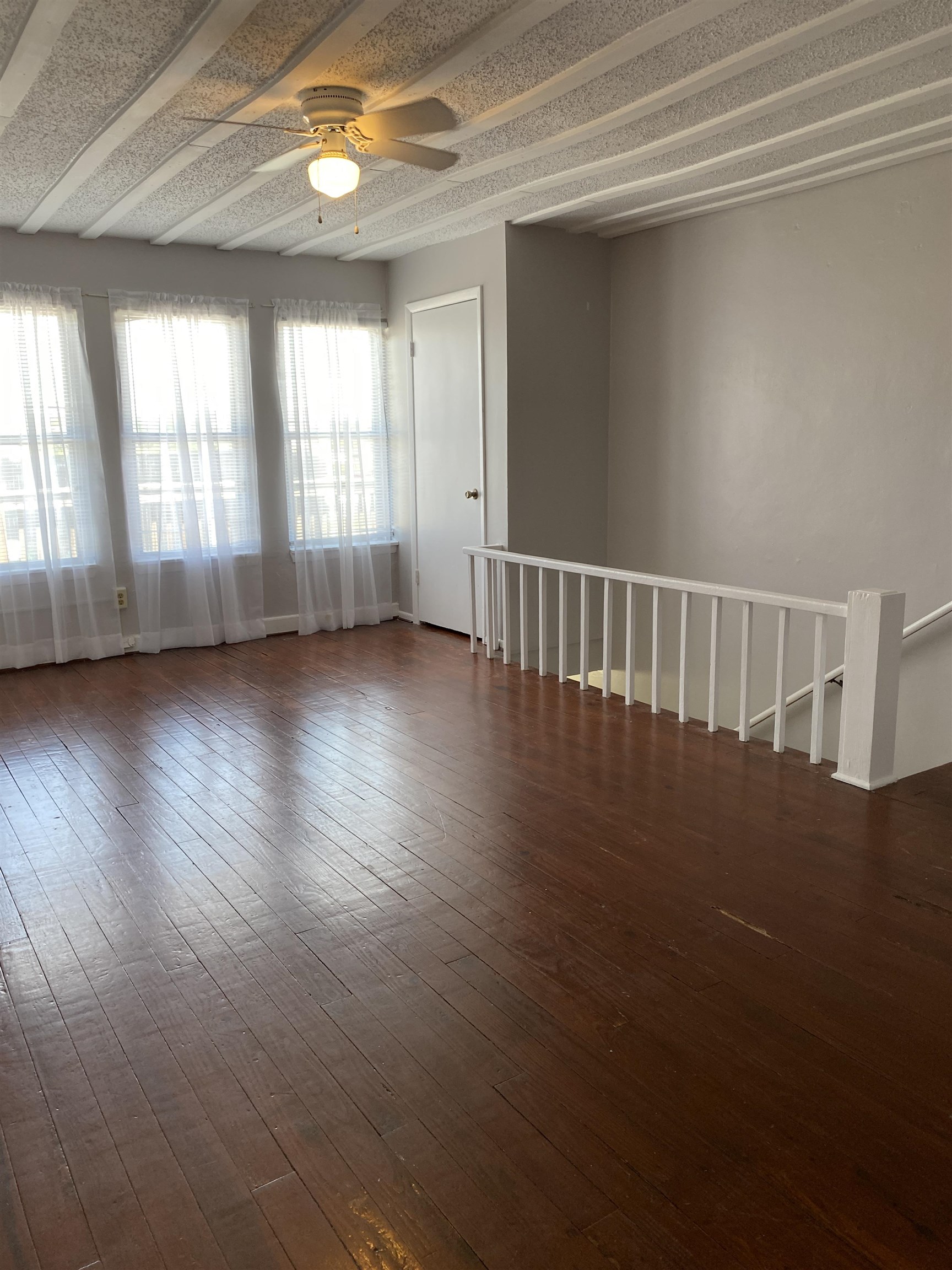 147 Riberia Street, Unit D St. Augustine, FL 32084 - Photo 6 of 19 an empty room with wooden floor and windows with curtains