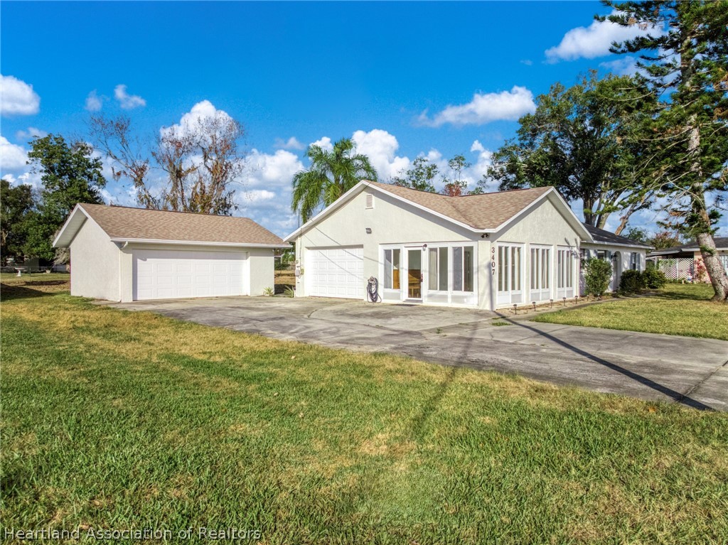 3407 Divot Road Sebring, FL 33872 - Photo 4 of 39 a front view of a house with a yard and garage