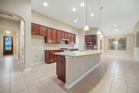 a large kitchen with a large counter top stainless steel appliances and cabinets