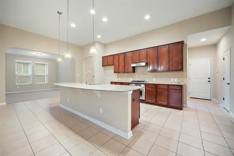 a kitchen with stainless steel appliances granite countertop a stove a sink and a refrigerator