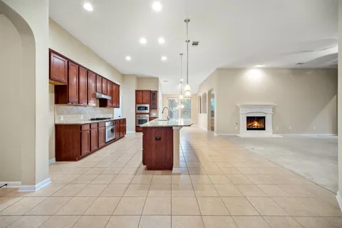 a kitchen with stainless steel appliances granite countertop a stove top oven a sink dishwasher and a refrigerator