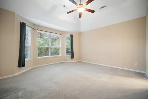 an empty room with windows and fan