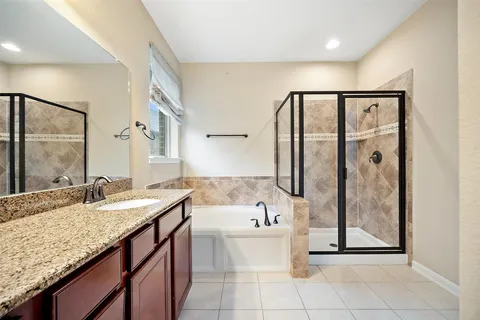 a bathroom with a granite countertop sink mirror and bathtub