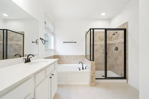 a bathroom with a tub a sink and mirror