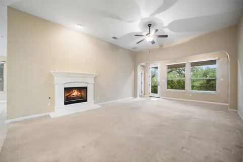 a view of an empty room with a fireplace and a window