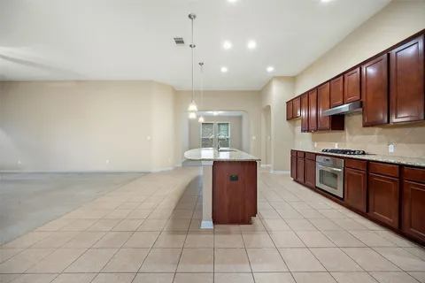 a large kitchen with stainless steel appliances cabinets a sink and a stove top oven