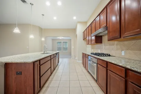 a large kitchen with stainless steel appliances granite countertop a stove and a sink