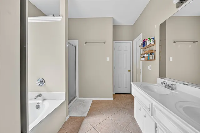 a spacious bathroom with a tub sink and mirror
