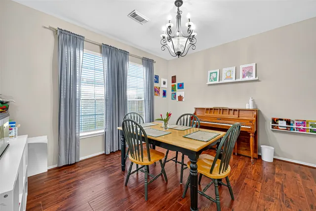a view of a dining room with furniture wooden floor and a chandelier