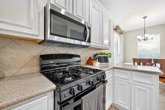 a kitchen with stainless steel appliances granite countertop a stove and a microwave