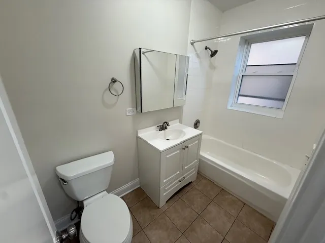 a white toilet sitting next to a bathroom sink and tub